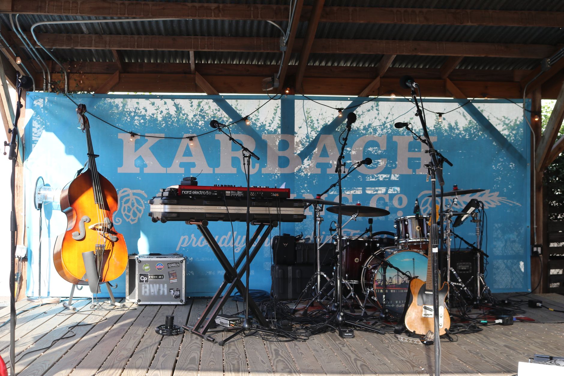 An outdoor stage with various musical instruments including a cello, drum set, and keyboard. — Trójmiasto