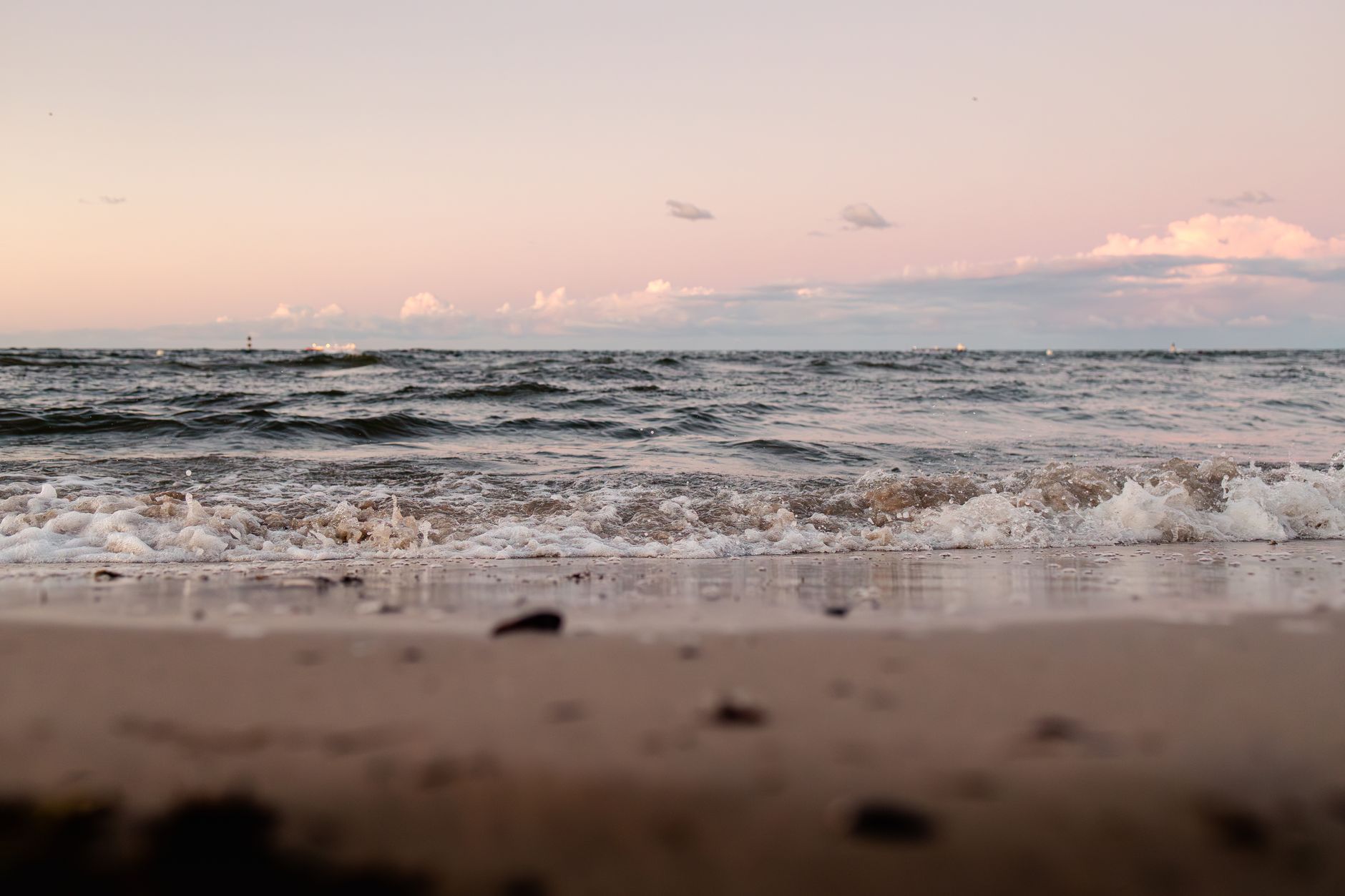 Serene sunset view of the Baltic Sea waves gently lapping the sandy shore. — Trójmiasto