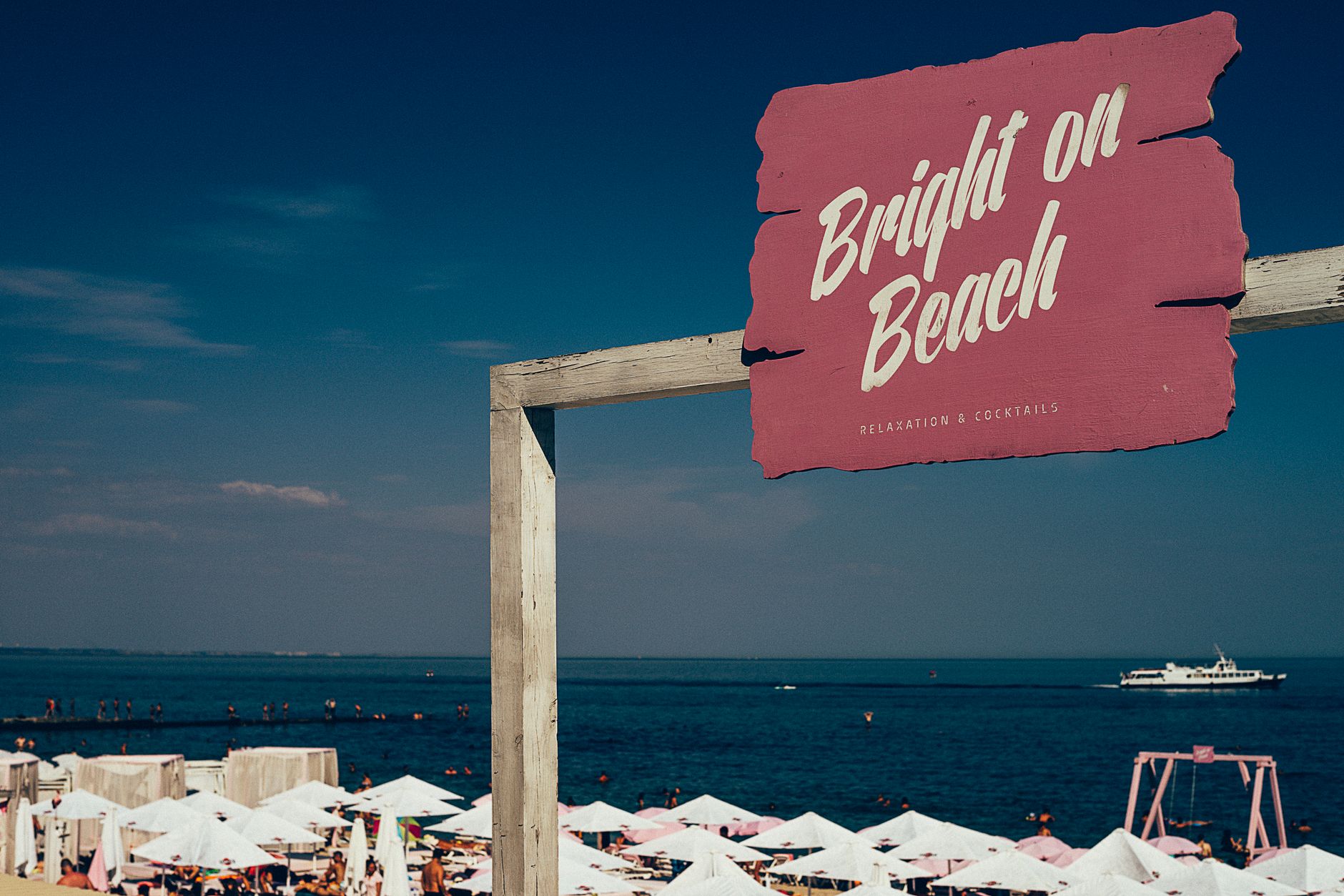 A vibrant beach scene with a 'Bright on Beach' sign, people enjoying summer by the sea. — Trójmiasto