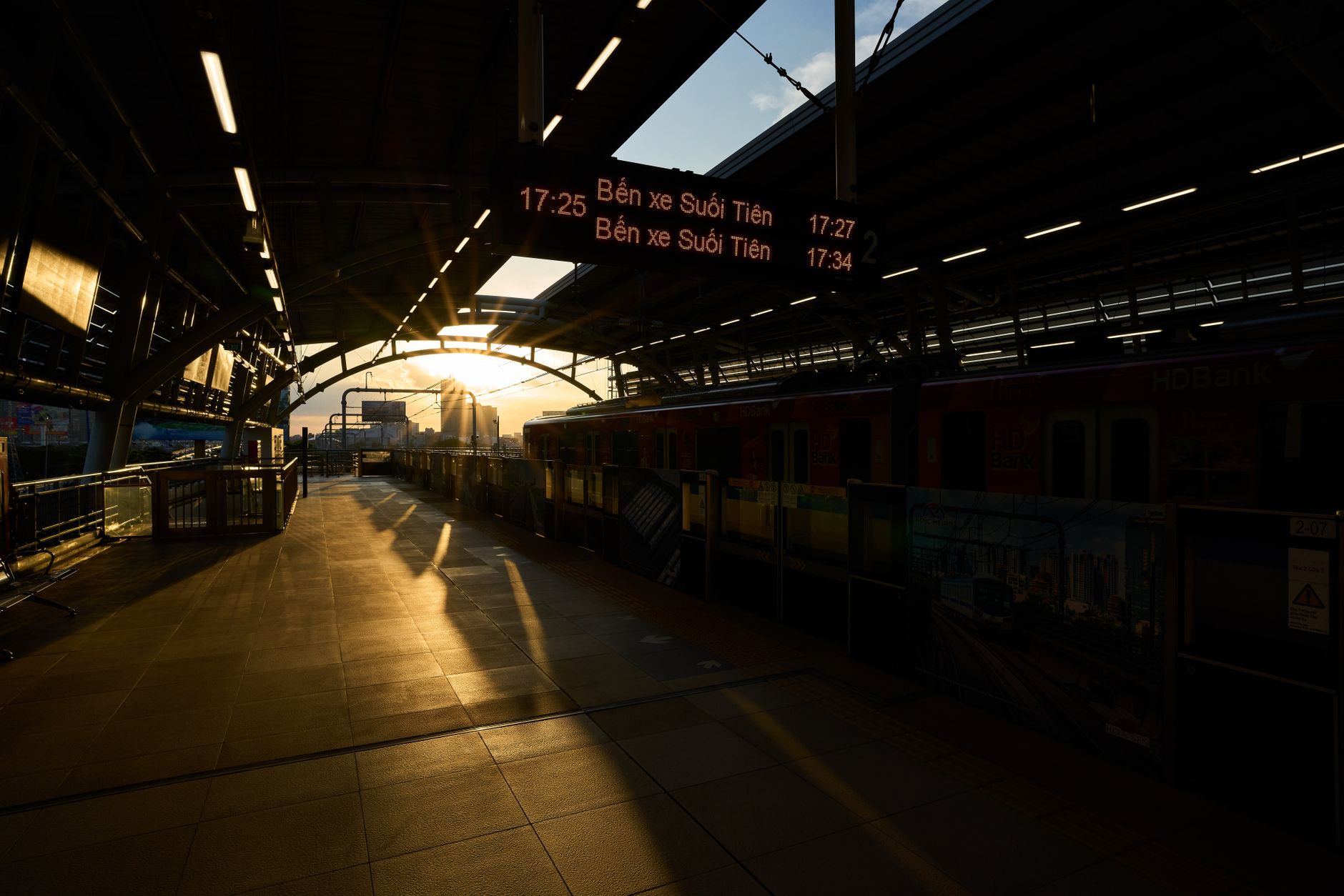 Golden hour at Hồ Chí Minh City train station with sunlit platform and urban view. — Trójmiasto