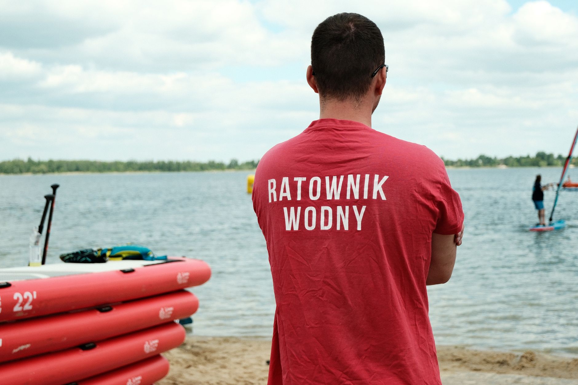 A lifeguard watches over paddleboarders at a lake in Polska, emphasizing safety. — Trójmiasto