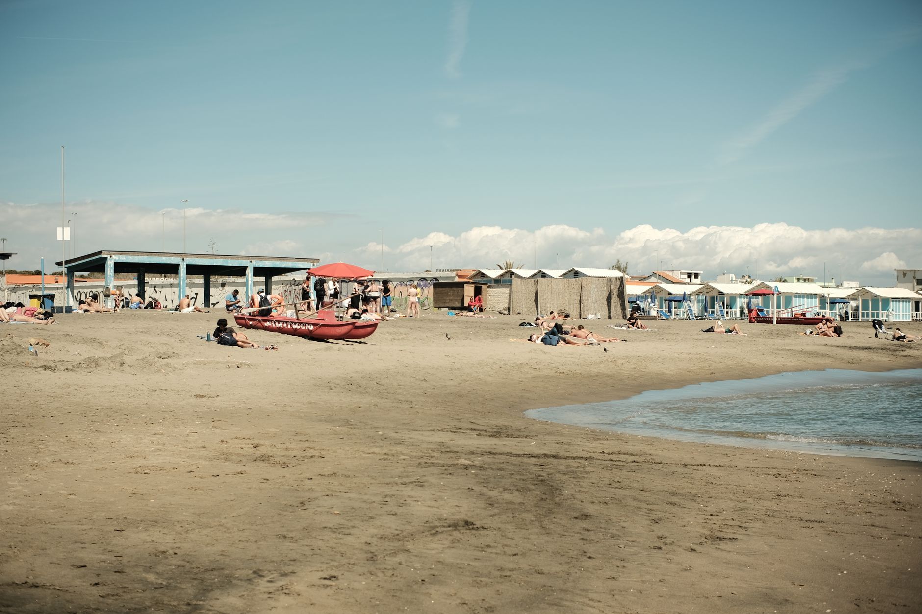 Enjoy a sunny day at Ostia beach in Lazio, Italy, with people lounging by the sea. — Trójmiasto