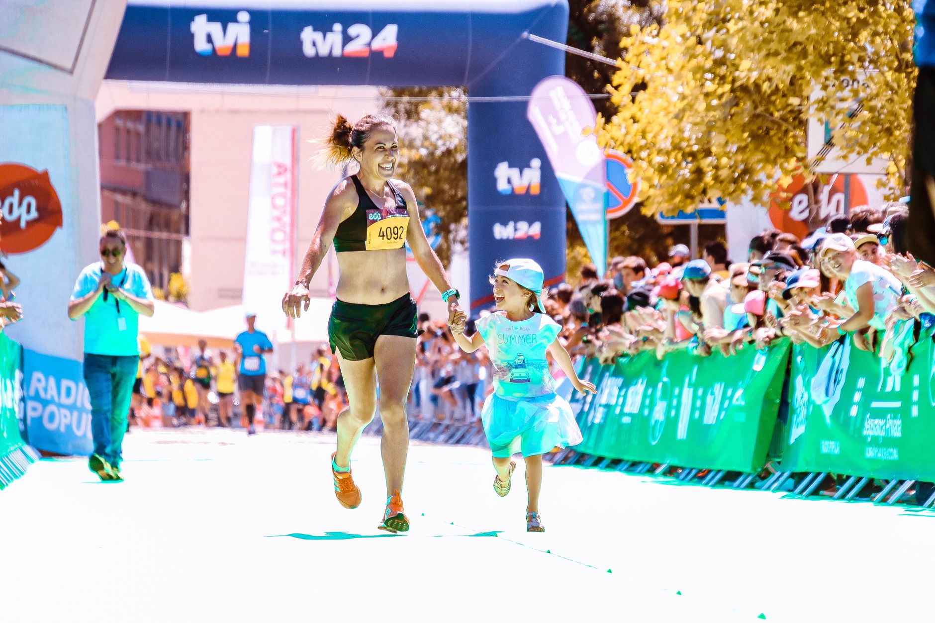A joyful mother and daughter cross the marathon finish line hand in hand, exuding happiness and energy. — Trójmiasto