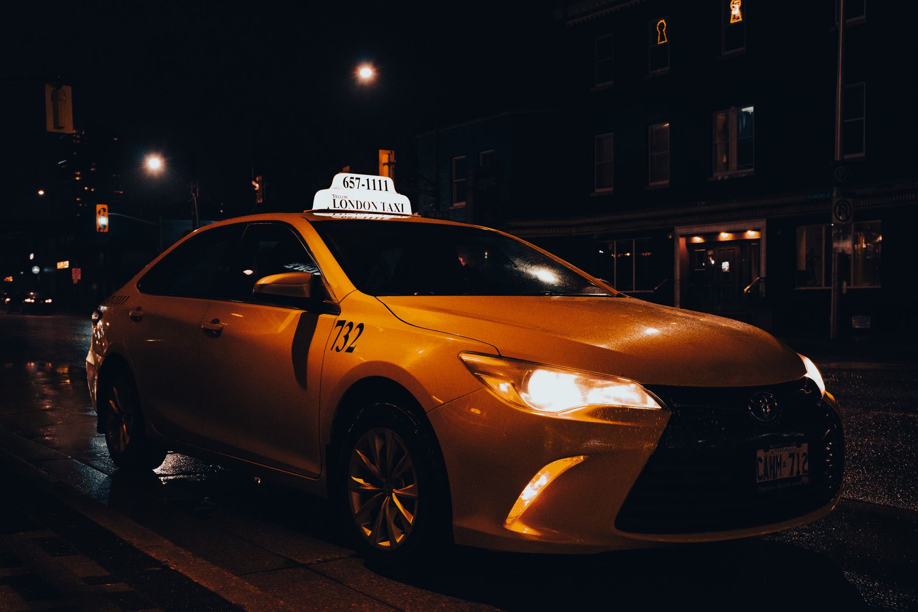 A yellow taxi waiting at night in London, Ontario, Canada. Urban transportation captured with street lights. — Trójmiasto