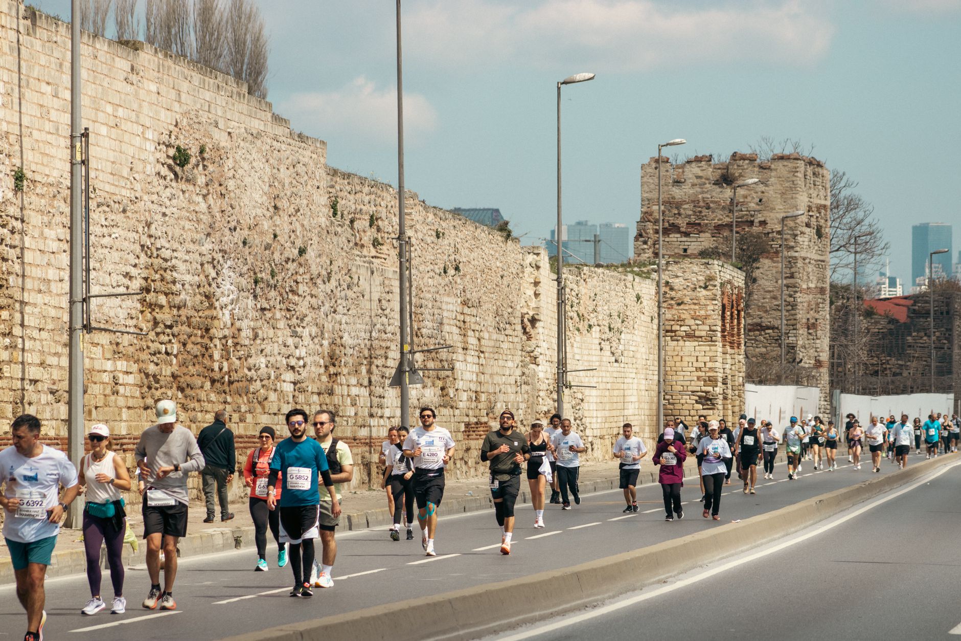 A dynamic scene of marathon runners beside ancient walls in Istanbul, Turkey. — Trójmiasto