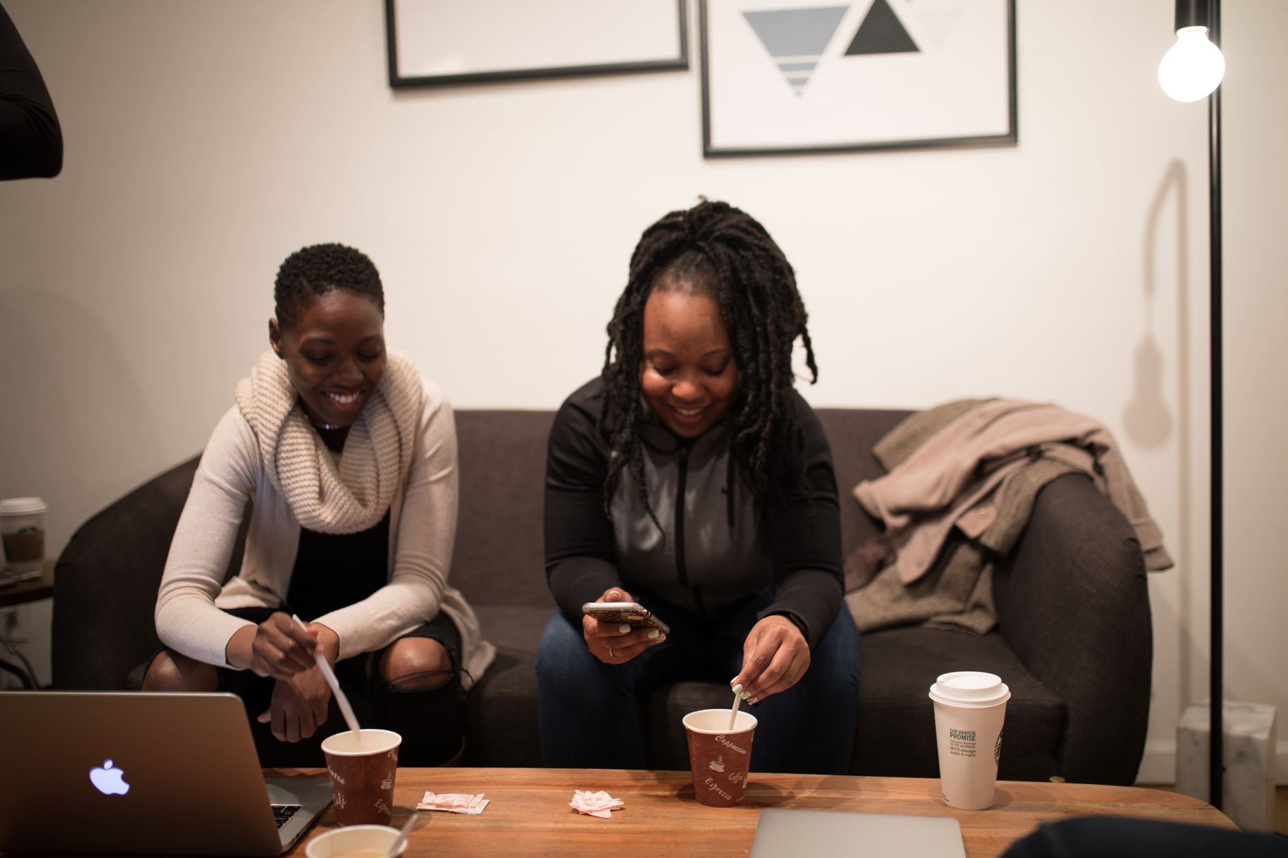 Two women enjoying coffee and a casual meeting in a cozy office setting. — Trójmiasto