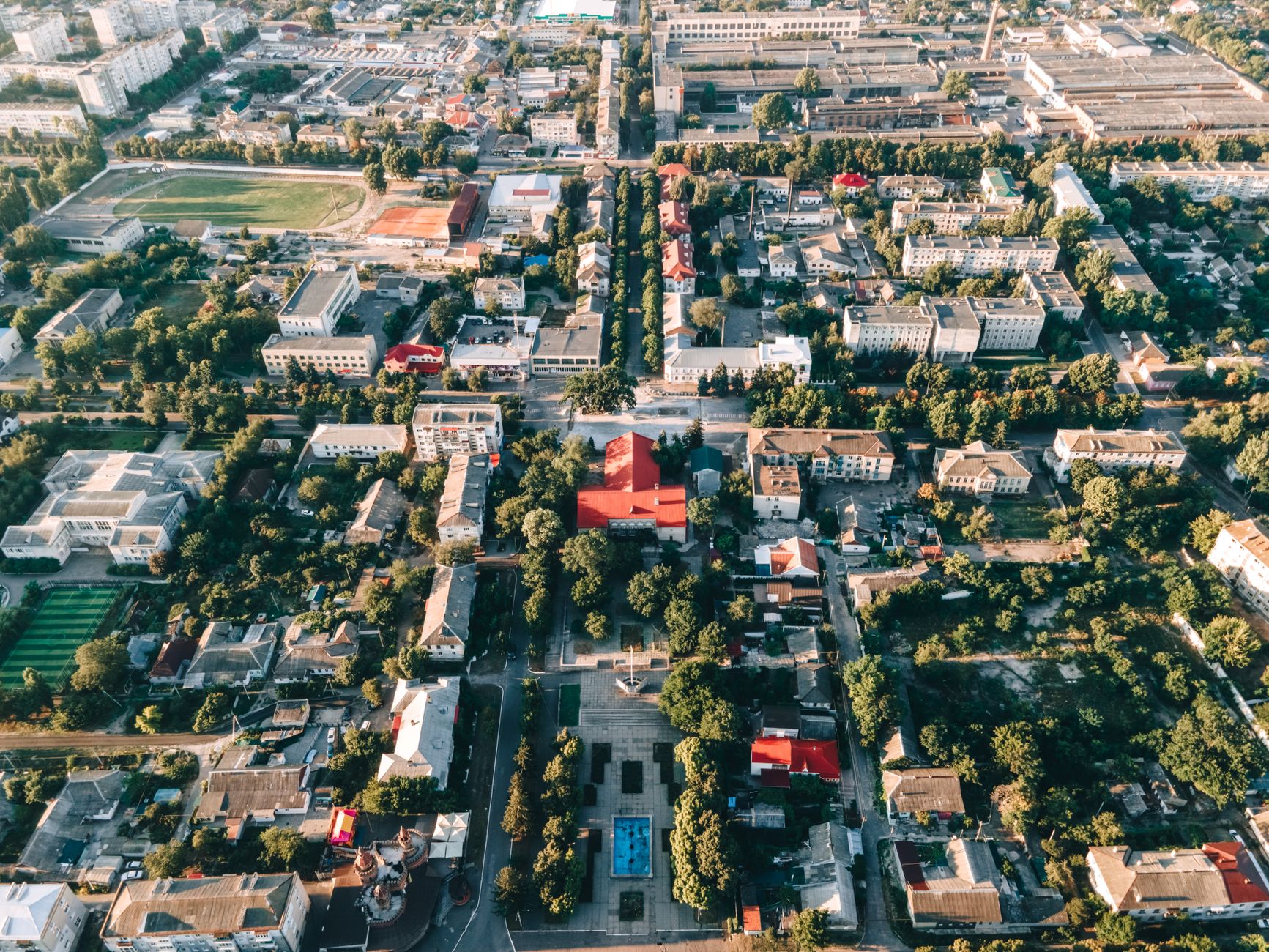 High-angle aerial view of a vibrant urban townscape with buildings and trees. — Trójmiasto